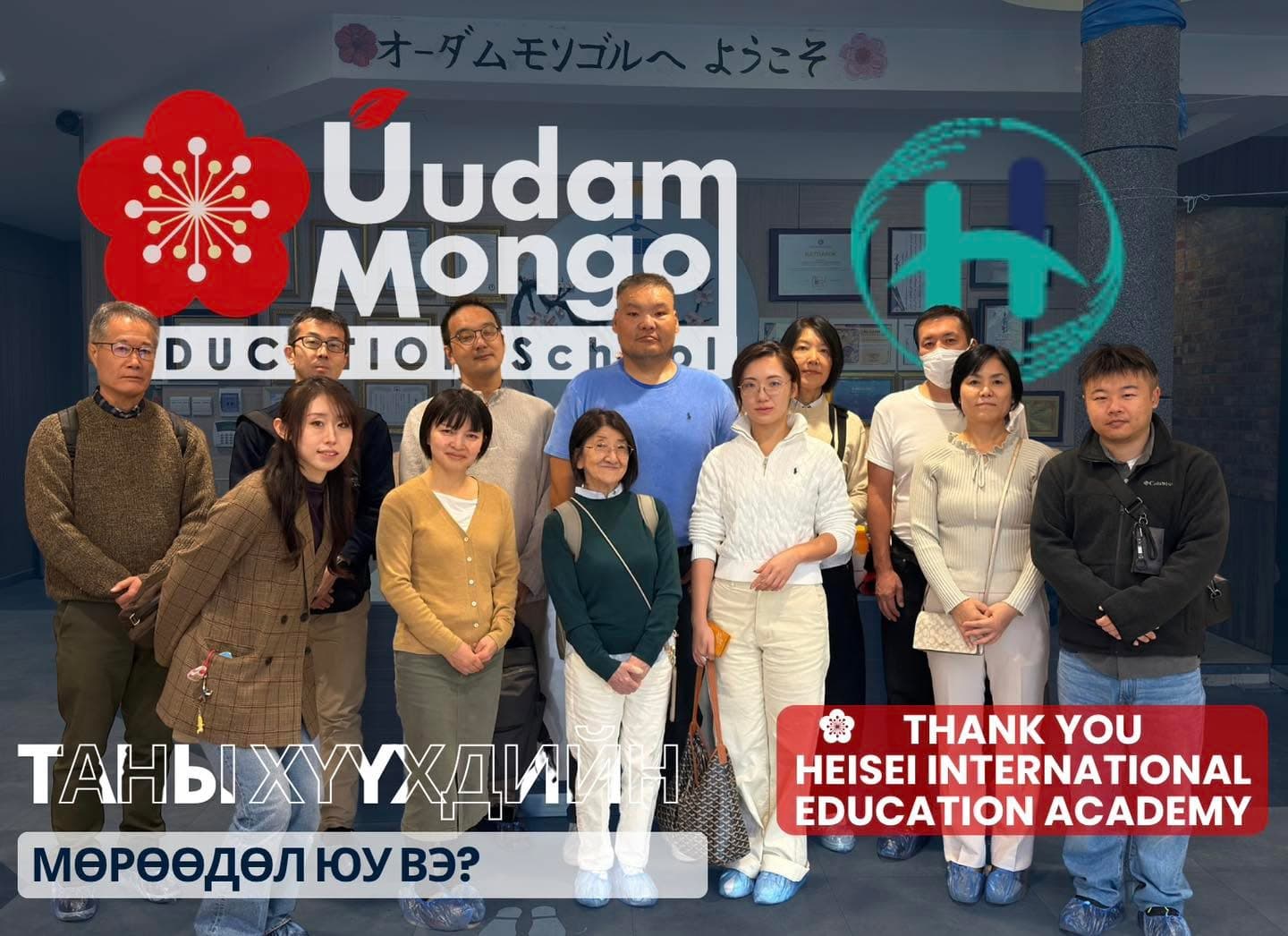 Уудам Монгол сургуулийн хүлээн авах танхимд Heisei International Education Academy-ийн төлөөлөгчид болон сургуулийн ажилтнууд хамт зогсож байна; ард нь японоор «Уудам Монголд тавтай морил» гэсэн бичиг харагдана. Зураг дээр Уудам Монгол сургуулийн улаан цэцгэн лого болон тус академийн оюу өнгийн «H» лого байрлуулсан. Мөн «THANK YOU HEISEI INTERNATIONAL EDUCATION ACADEMY» гэсэн талархлын бичиг болон «Таны хүүхдийн мөрөөдөл юу вэ?» гэсэн бичиг бий.