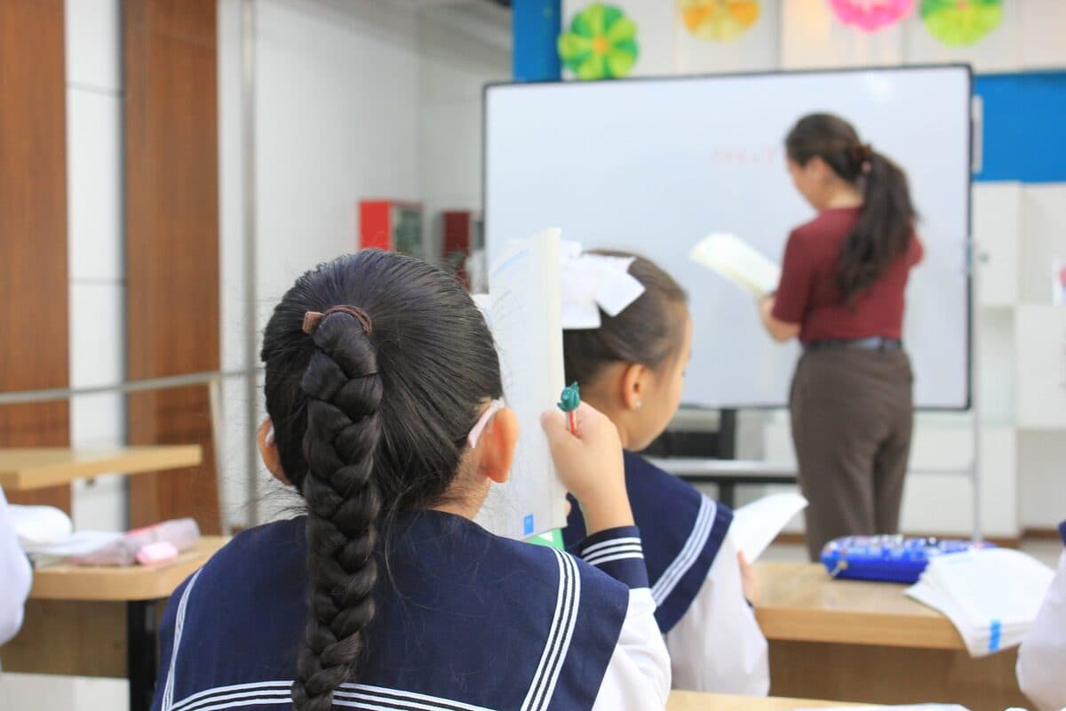 A student working at the board with a teacher